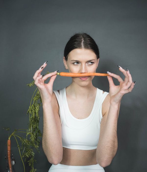 Woman holding a graceful yoga pose in a bright, modern studio.